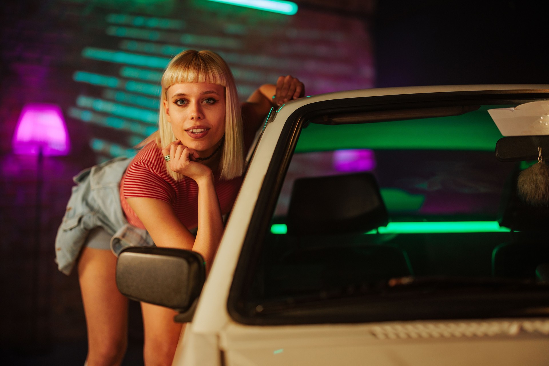 Fashionable girl standing next to car.